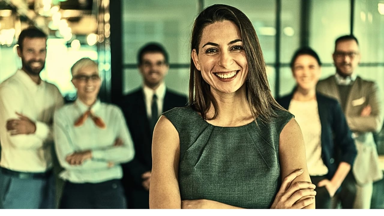 A confident woman standing in front of her team